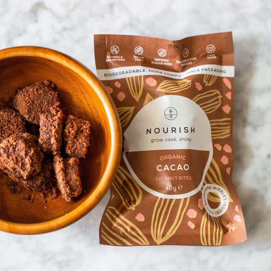 Nourish Organic Cacao Coconut Bites packaging with a bowl of bites on a white background