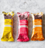 Three packaged food items labeled 'The Nutty One', 'The Berry One', and 'The Orange One' on a light gray background.